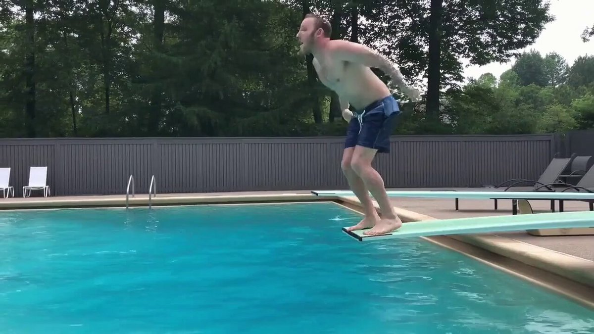 man does a cannonball off diving board