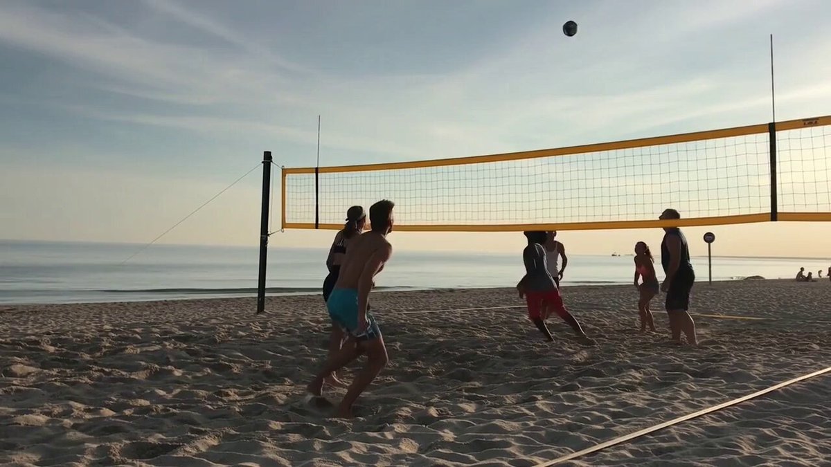 a group people playing volleyball